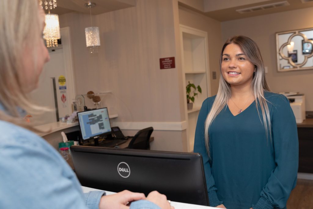 A woman talking to the receptionist
